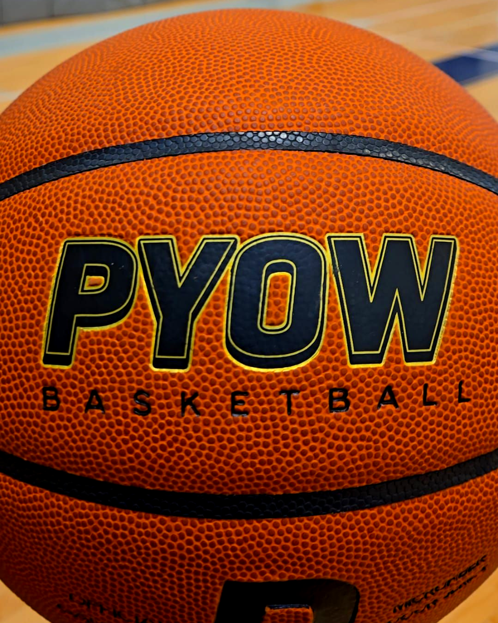 Basketball with 'PYOW' branding on a wooden floor background