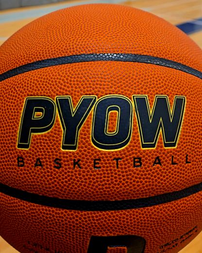Basketball with 'PYOW' branding on a wooden floor background